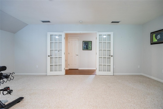 unfurnished room featuring carpet flooring, french doors, and lofted ceiling