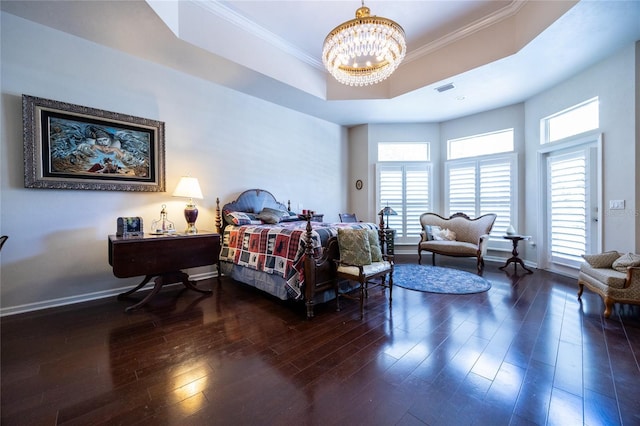 bedroom featuring a chandelier, dark hardwood / wood-style floors, ornamental molding, and a tray ceiling