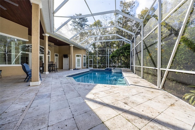 view of swimming pool with glass enclosure, ceiling fan, and a patio