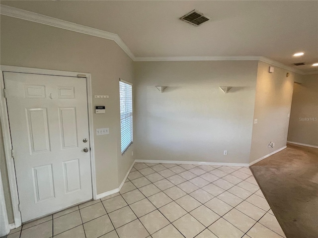 tiled foyer entrance featuring crown molding