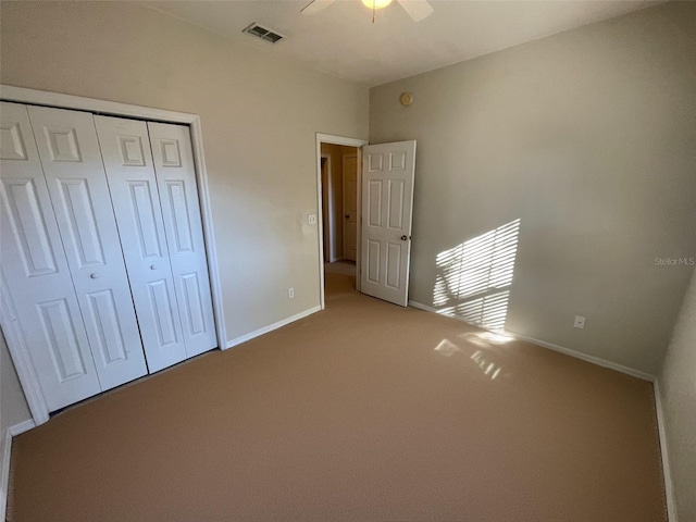 unfurnished bedroom featuring carpet, ceiling fan, and a closet