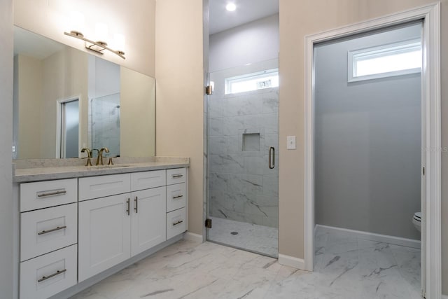 bathroom featuring vanity, a shower with door, toilet, and a wealth of natural light