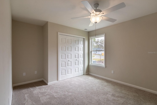 unfurnished bedroom with ceiling fan, a closet, and carpet floors