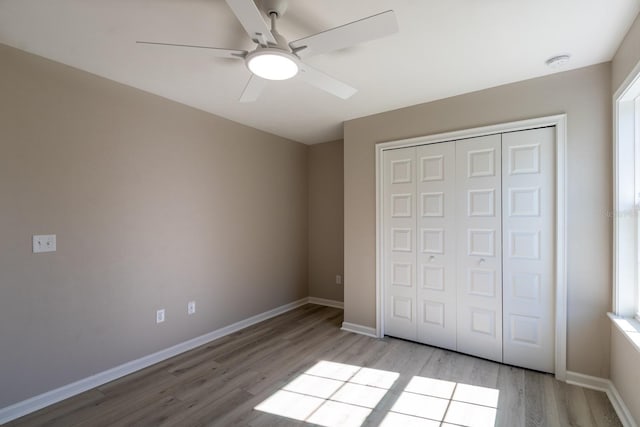 11828 NW 15th Rd, Gainesville, FL 32606 - unfurnished bedroom featuring a closet, baseboards, light wood-type flooring, and ceiling fan