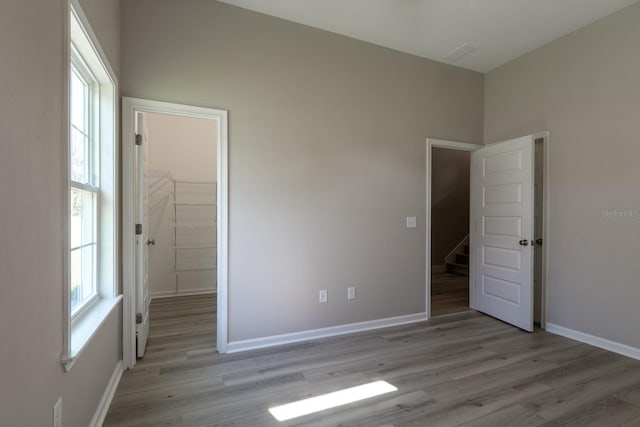 11828 NW 15th Rd, Gainesville, FL 32606 - empty room with stairway, baseboards, and wood finished floors