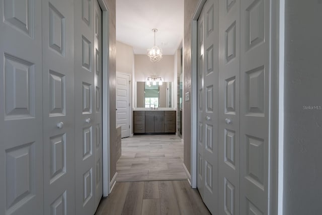 11828 NW 15th Rd, Gainesville, FL 32606 - hallway featuring a chandelier and light wood-style floors