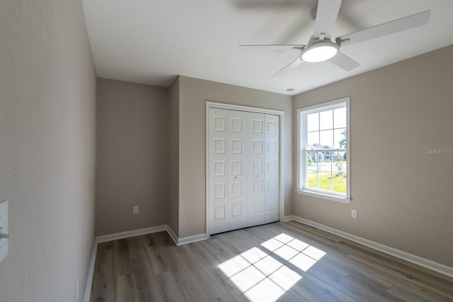 11828 NW 15th Rd, Gainesville, FL 32606 - unfurnished bedroom featuring a closet, baseboards, a ceiling fan, and wood finished floors