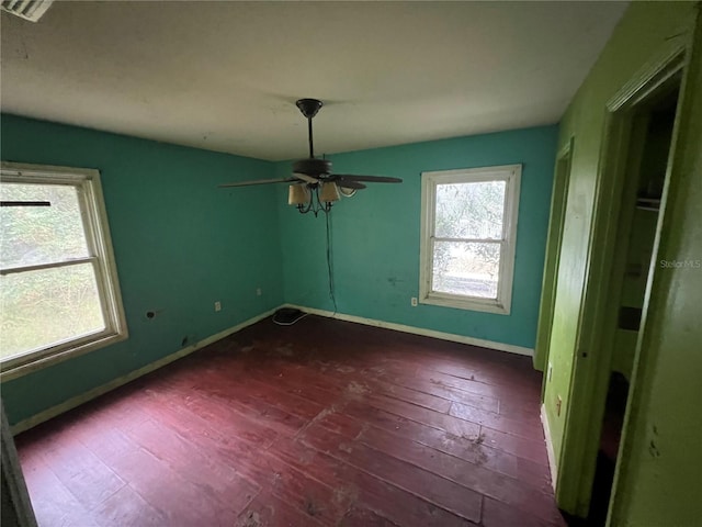 empty room with ceiling fan and dark hardwood / wood-style floors