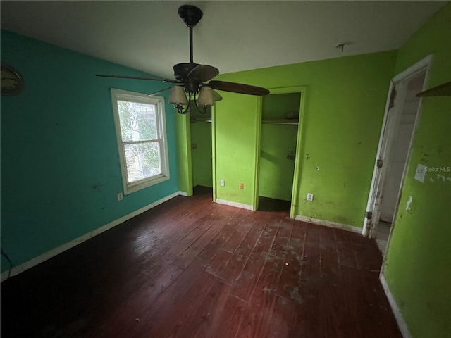 unfurnished bedroom featuring ceiling fan and dark wood-type flooring