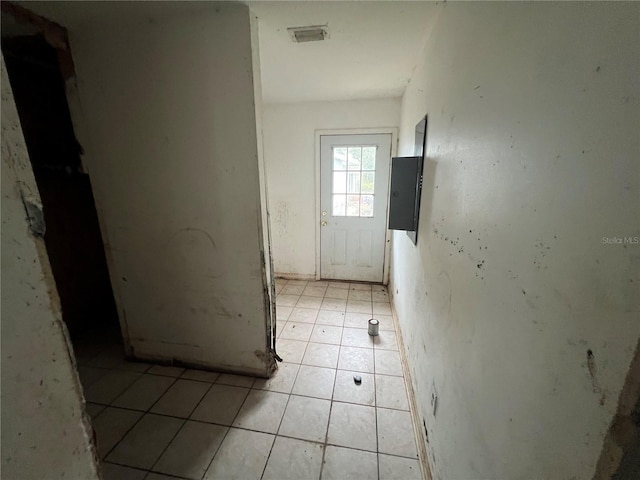 interior space with light tile patterned floors and electric panel