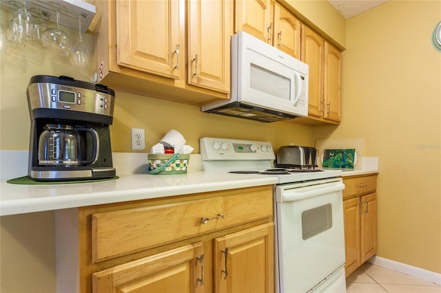 kitchen with light tile patterned flooring and white appliances