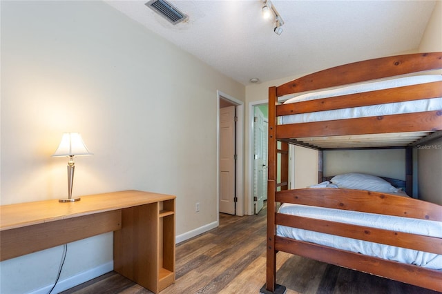 bedroom with a textured ceiling and dark hardwood / wood-style floors