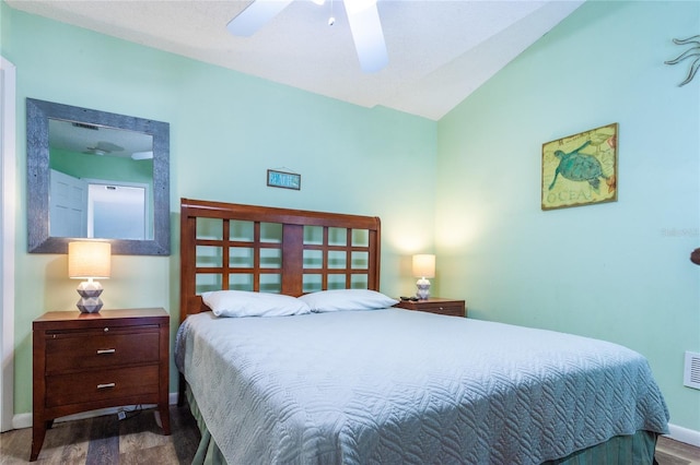 bedroom featuring ceiling fan, dark hardwood / wood-style floors, and vaulted ceiling