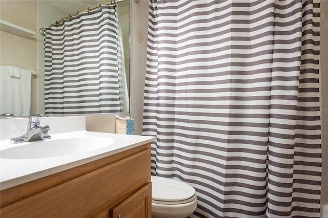 bathroom with vanity, curtained shower, and toilet