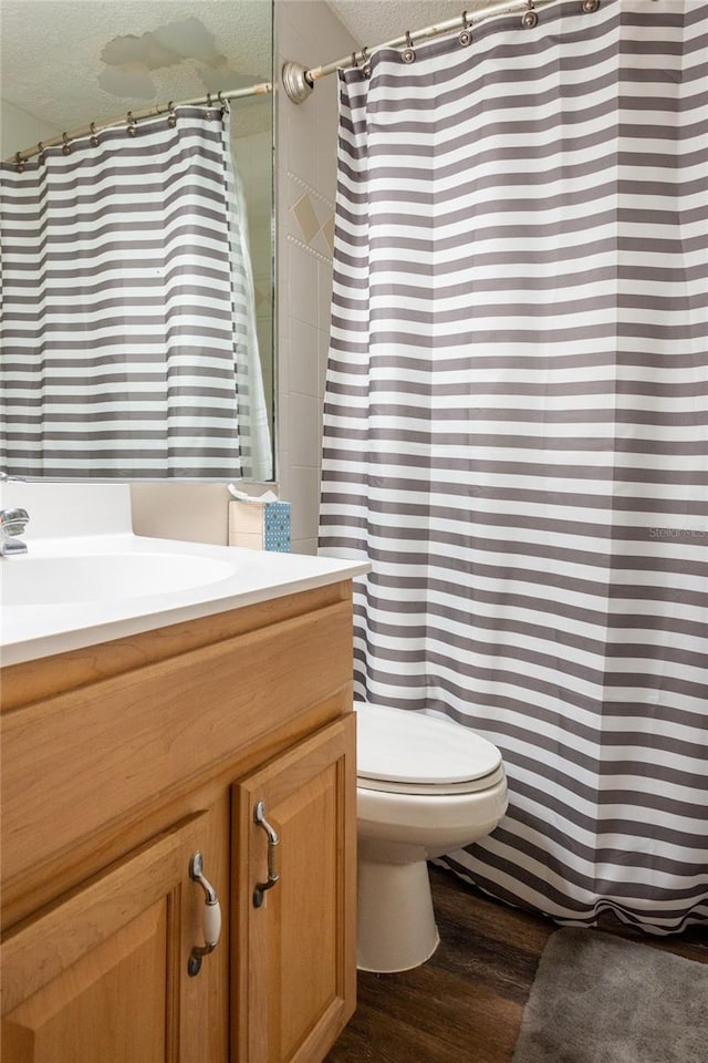 bathroom with vanity, hardwood / wood-style floors, a textured ceiling, and toilet