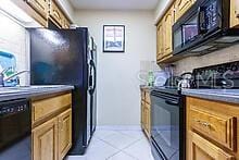 kitchen featuring light tile patterned floors, sink, and black appliances