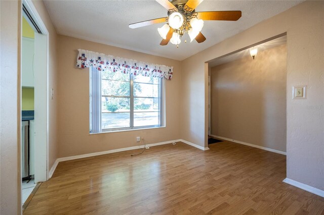 unfurnished room featuring hardwood / wood-style flooring, ceiling fan, and a textured ceiling