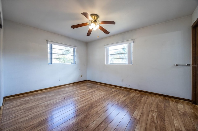 empty room featuring ceiling fan, a healthy amount of sunlight, and light wood-type flooring