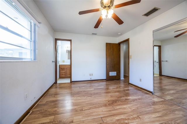 unfurnished bedroom with hardwood / wood-style floors, ensuite bathroom, and ceiling fan