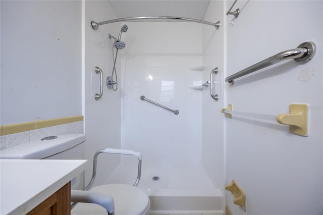 bathroom featuring a shower, vanity, and toilet