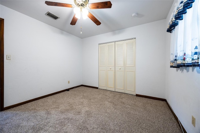 unfurnished bedroom featuring ceiling fan, a closet, and carpet