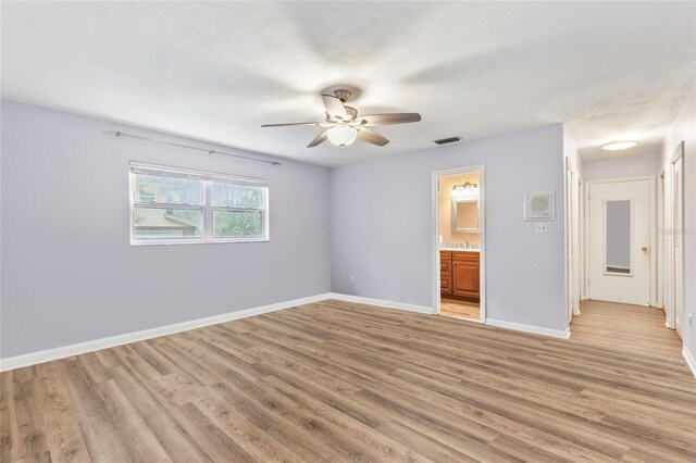 unfurnished bedroom with ensuite bath, ceiling fan, and light hardwood / wood-style floors