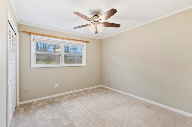 unfurnished room featuring light colored carpet, ceiling fan, and crown molding