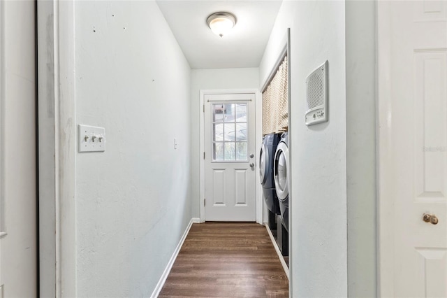 clothes washing area with washer and dryer and dark wood-type flooring