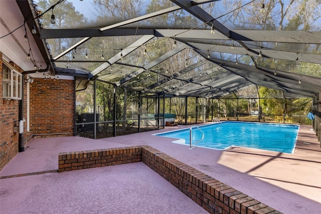 view of swimming pool featuring a patio area, glass enclosure, and a hot tub