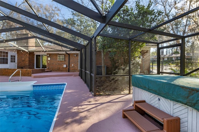 view of swimming pool with glass enclosure and a patio area