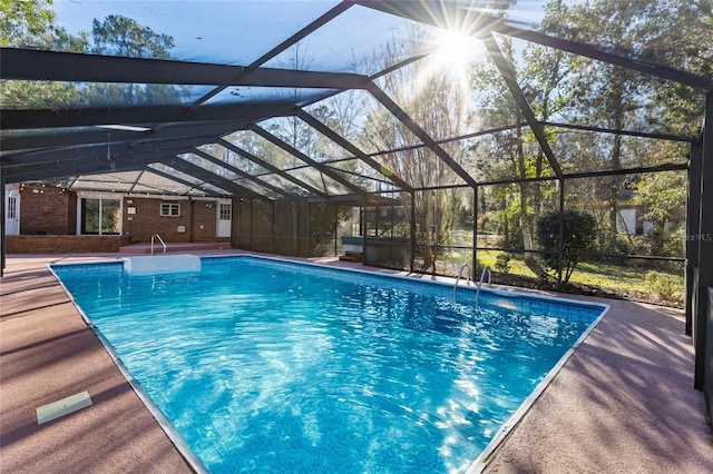 view of swimming pool featuring glass enclosure and a patio area