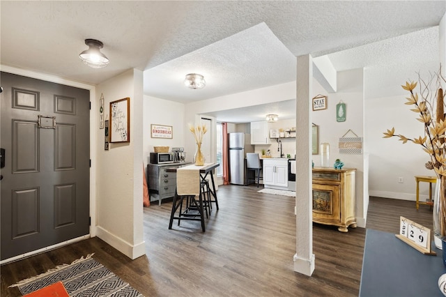 foyer entrance with a textured ceiling, sink, and dark hardwood / wood-style floors