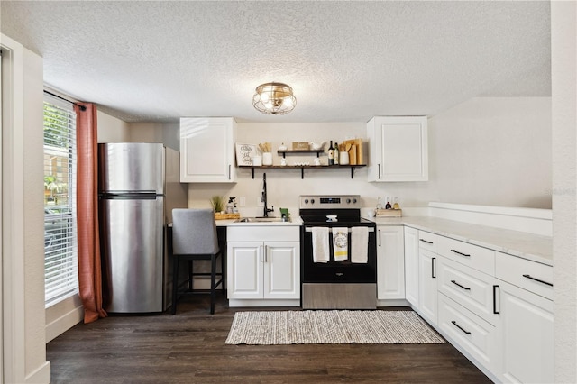 kitchen featuring white cabinetry, sink, dark hardwood / wood-style floors, a textured ceiling, and appliances with stainless steel finishes