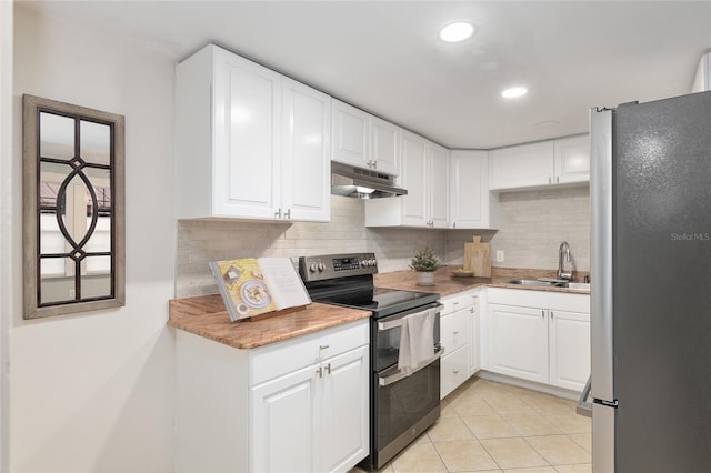 kitchen featuring appliances with stainless steel finishes, backsplash, light tile patterned flooring, white cabinets, and sink