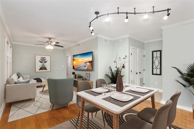 dining space featuring light hardwood / wood-style floors, crown molding, and ceiling fan