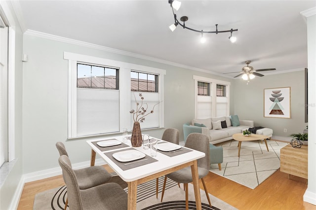 dining space with ceiling fan, ornamental molding, rail lighting, and light hardwood / wood-style flooring