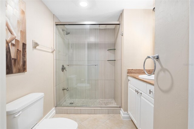 bathroom featuring toilet, tile patterned flooring, an enclosed shower, and vanity