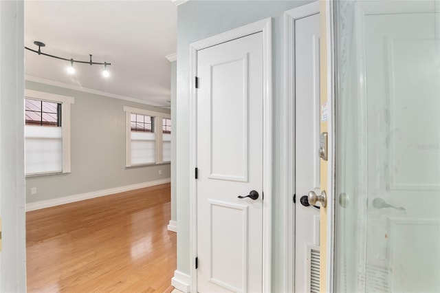 hallway featuring light wood-type flooring and crown molding