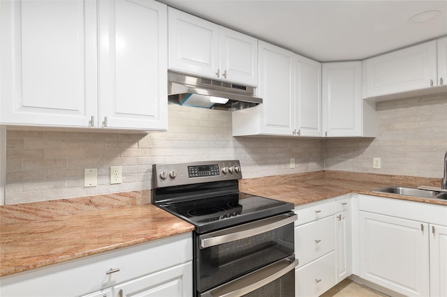 kitchen featuring double oven range, white cabinets, and sink