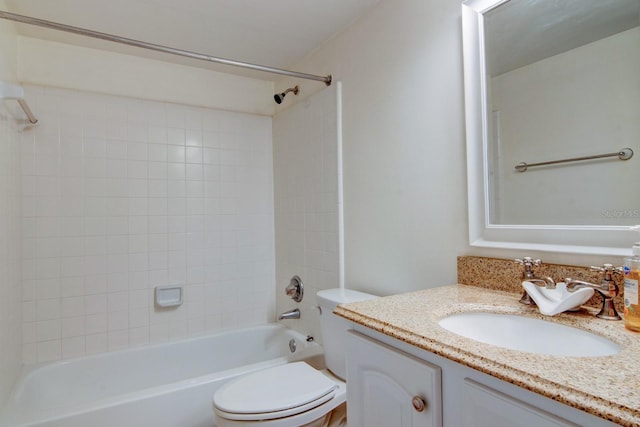 full bathroom featuring tiled shower / bath, vanity, and toilet