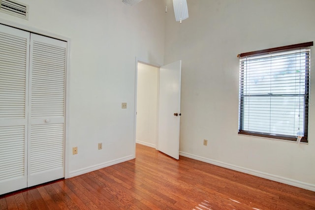 unfurnished bedroom with ceiling fan, light hardwood / wood-style floors, and a closet