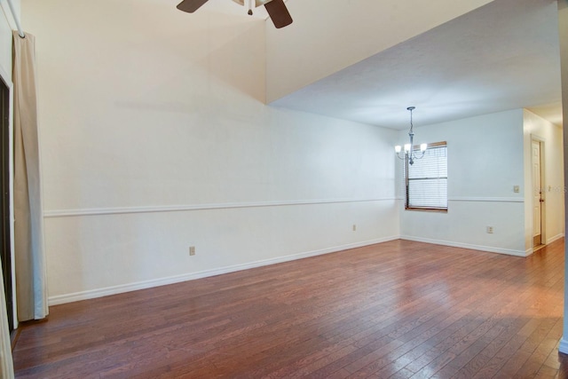 empty room featuring dark hardwood / wood-style flooring and ceiling fan with notable chandelier