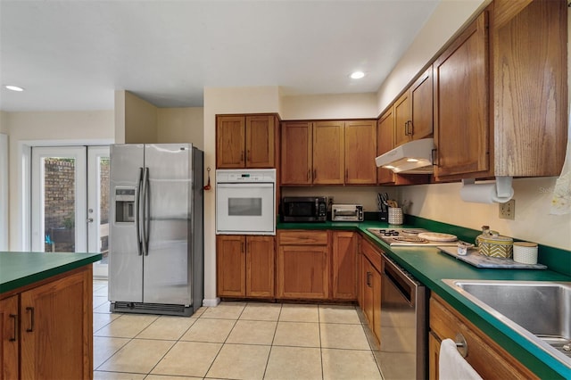 kitchen featuring appliances with stainless steel finishes, light tile patterned floors, and sink