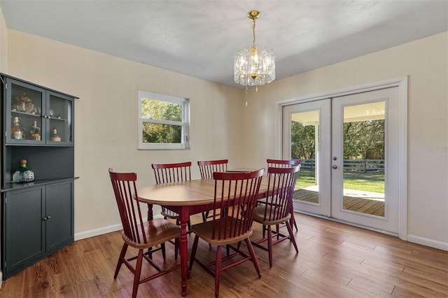 dining room with a notable chandelier, plenty of natural light, and french doors