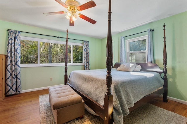 bedroom featuring multiple windows, ceiling fan, and hardwood / wood-style floors