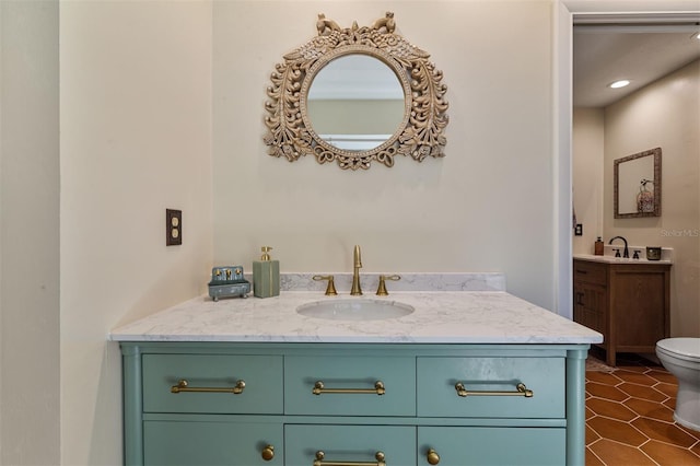 bathroom with tile patterned flooring, vanity, and toilet