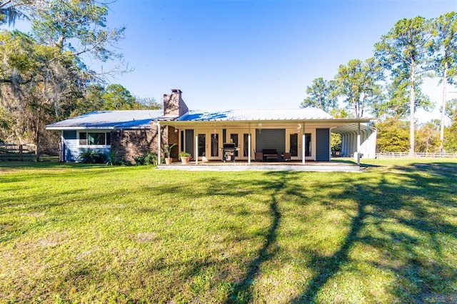 rear view of property with a lawn and a patio area