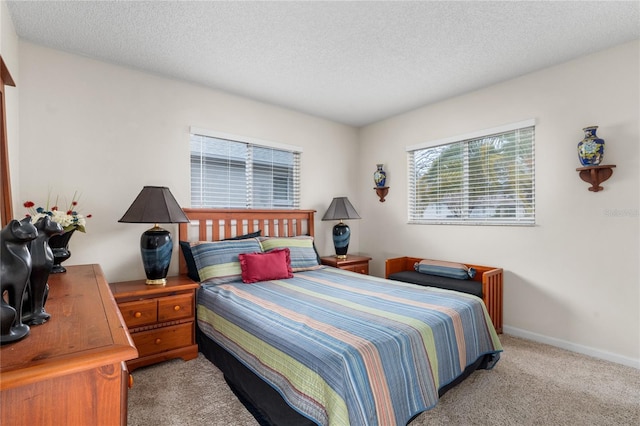 bedroom featuring light carpet and a textured ceiling