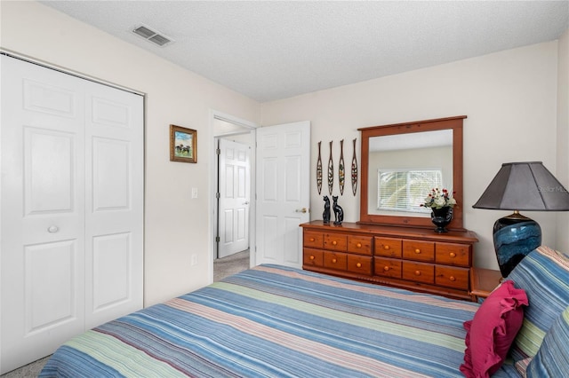 bedroom with carpet floors, a textured ceiling, and a closet