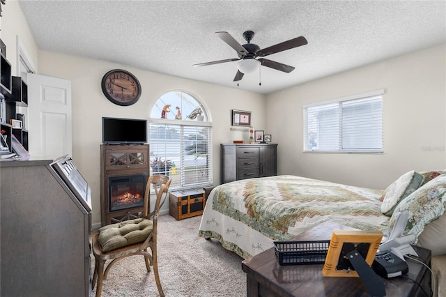 carpeted bedroom with a textured ceiling and ceiling fan